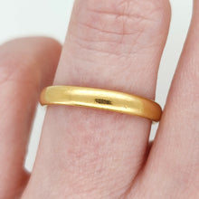 Load image into Gallery viewer, A plain yellow gold wedding band ring, modelled on a hand