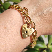 Load image into Gallery viewer, A yellow gold double link bracelet with a heart padlock and safety chain, modelled on a wrist