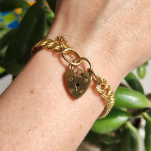 Load image into Gallery viewer, A yellow gold double link bracelet with a heart padlock and safety chain, modelled on a wrist
