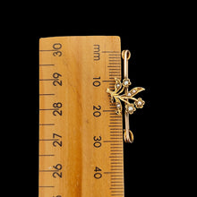 Load image into Gallery viewer, A yellow gold floral bar brooch with seed pearls, next to a ruler