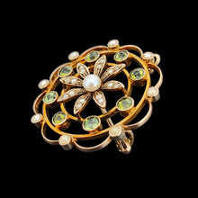 Load image into Gallery viewer, A circular brooch/pendant in yellow gold with peridots and pearls, with a flower to the centre, on a black background