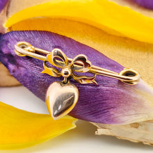 Load image into Gallery viewer, Antique 9ct Gold Heart and Bow Bar Brooch resting on purple and yellow flower petals