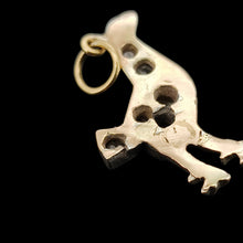 Load image into Gallery viewer, A diamond set bird charm in silver and yellow gold, on a black background