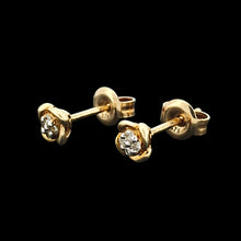 Load image into Gallery viewer, A pair of yellow gold diamond stud earrings, on a black background