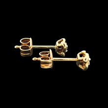 Load image into Gallery viewer, A pair of yellow gold diamond stud earrings, on a black background