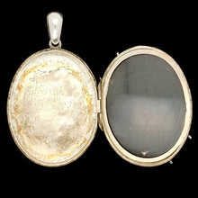 Load image into Gallery viewer, An oval silver locket pendant on a black background