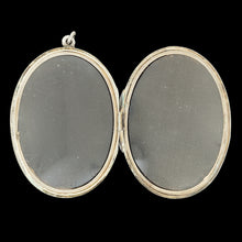 Load image into Gallery viewer, A silver oval locket pendant, on a black background