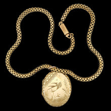 Load image into Gallery viewer, An oval locket with bird engraving with a Venetian link chain in yellow metal, on a black background