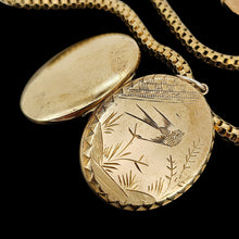 Load image into Gallery viewer, An oval locket with bird engraving, open, with a Venetian link chain in yellow metal, on a black background