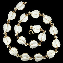 Load image into Gallery viewer, A white enamel leaf necklace in silver gilt, on a black background