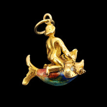 Load image into Gallery viewer, A gold pendant depicting a figure riding a fish, on a black background. The fish has colourful enamel scales in blue, green, and orange. A gold chain connects the figure to the fish. The pendant has a small gold loop at the top for attaching to a chain.