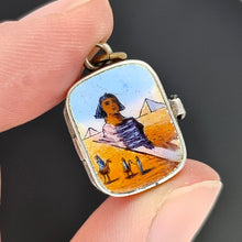 Load image into Gallery viewer, Pendant with an enamelled Egyptian desert scene held between fingers against a dark background