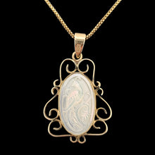 Load image into Gallery viewer, An oval yellow gold and mother of pearl pendant carved with a bird, with a gold chain, on a black background