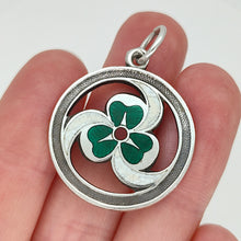 Load image into Gallery viewer, A silver enamel clover triskelion pendant, held in a hand