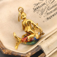Load image into Gallery viewer, A gold pendant depicting a figure riding a fish, sat in an antique box. The fish has colourful enamel scales in blue, green, and orange. A gold chain connects the figure to the fish. The pendant has a small gold loop at the top for attaching to a chain.