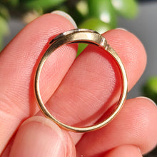 Load image into Gallery viewer, A three stone rose cut diamond ring in yellow gold and palladium, held in a hand