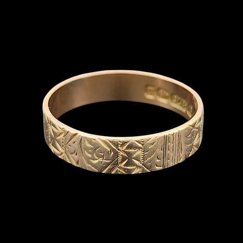 Antique gold ring with intricate patterns on a black background