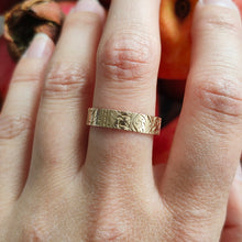 Load image into Gallery viewer, Gold ring with intricate design on a finger against a blurred background
