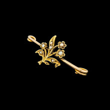 Load image into Gallery viewer, A yellow gold floral bar brooch with seed pearls, on a black background
