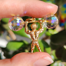 Load image into Gallery viewer, A yellow gold weightlifter charm pendant with a crystal barbell, held in a hand
