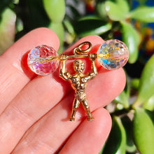 Load image into Gallery viewer, A yellow gold weightlifter charm pendant with a crystal barbell, held in a hand
