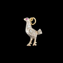 Load image into Gallery viewer, A diamond set bird charm in silver and yellow gold, with a ruby eye, on a black background
