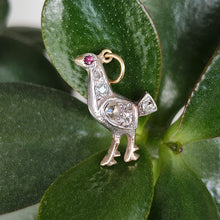 Load image into Gallery viewer, A diamond set bird charm in silver and yellow gold, with a ruby eye, with leaves
