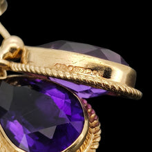 Load image into Gallery viewer, A pair of pear shaped amethyst drop earrings in yellow gold rope edge mounts, showing a close-up of a Birmingham 1987 hallmark, on a black background
