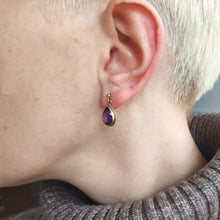 Load image into Gallery viewer, A pear shaped amethyst drop earring in yellow gold rope edge mount, modelled in an ear
