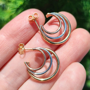 9ct Yellow, Rose and White Gold Triple Hoop Earrings held in the hand