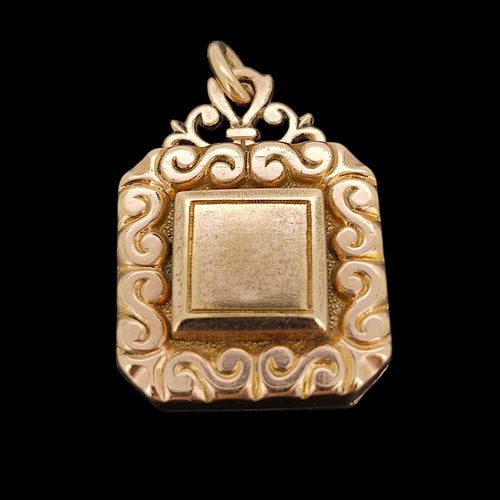 Antique Rolled Gold Ornate Locket Pendant shown from the front, on a black background