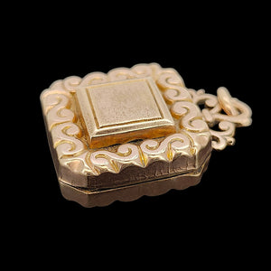 Antique Rolled Gold Ornate Locket Pendant shown from the side, on a black background