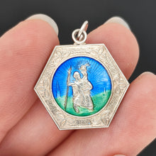Load image into Gallery viewer, A hexagonal silver Saint Christopher pendant with blue and green enamel, held in a hand

