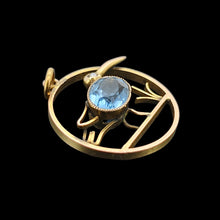 Load image into Gallery viewer, A circular cutout pendant featuring a wading bird with a blue paste stone body, in yellow gold, on a black background
