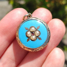 Load image into Gallery viewer, Victorian 9ct Gold Enamel, Pearl and Garnet Glazed Back Pendant held in the hand
