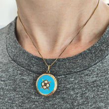 Load image into Gallery viewer, Victorian 9ct Gold Enamel, Pearl and Garnet Glazed Back Pendant modelled with a gold chain against a grey t-shirt
