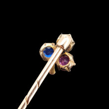 Load image into Gallery viewer, A ruby, sapphire and diamond clover shaped stick tie pin in gold, on a black background

