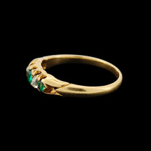 Load image into Gallery viewer, An emerald and diamond graduated five stone ring in yellow gold, on a black background
