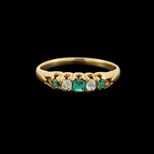 Load image into Gallery viewer, An emerald and diamond graduated five stone ring in yellow gold, on a black background
