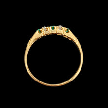 Load image into Gallery viewer, An emerald and diamond graduated five stone ring in yellow gold, on a black background
