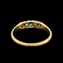 Load image into Gallery viewer, An emerald and diamond graduated five stone ring in yellow gold, on a black background
