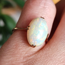 Load image into Gallery viewer, A single stone oval shaped, cabochon cut opal ring in rose gold, modelled on a hand
