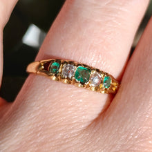 Load image into Gallery viewer, An emerald and diamond graduated five stone ring in yellow gold, modelled on a hand
