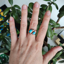 Load image into Gallery viewer, A rose gold double snake band ring with turquoise heads, modelled on a hand
