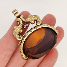 Load image into Gallery viewer, Large Antique 9ct Gold Cased Orange Glass Spinner Fob in hand
