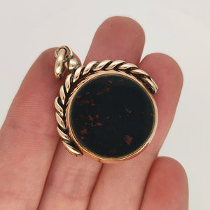 Antique 9ct Rose Gold Bloodstone & Carnelian Round Swivel Fob in hand