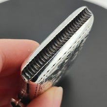 Load image into Gallery viewer, Close-up of the bottom of a silver vesta case, held in a hand, showing the match strike section
