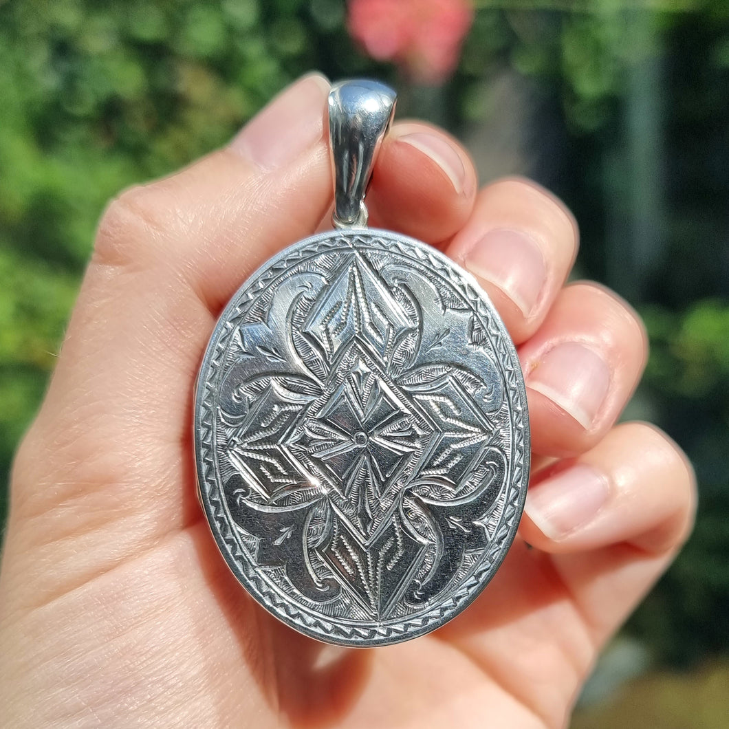 Antique Silver Engraved Locket Pendant in hand